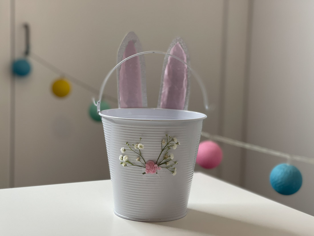 Easter Bunny Basket made from white bucket with paper bunny ears and pink tissue nose