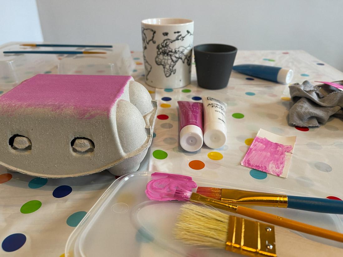 Table with craft tools and painted egg box